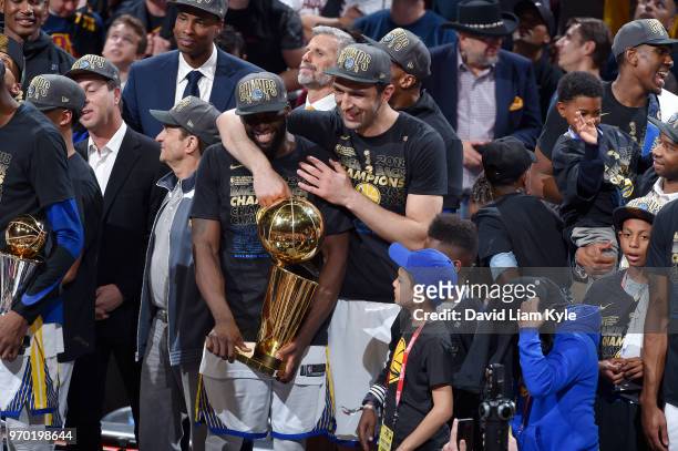 Zaza Pachulia and Draymond Green of the Golden State Warriors celebrate as they hold the Larry O'Brien NBA Championship Trophy after Game Four of the...