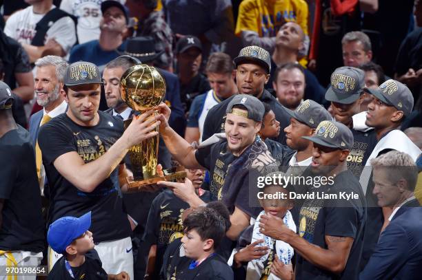 Zaza Pachulia and Klay Thompson of the Golden State Warriors celebrate as they hold the Larry O'Brien NBA Championship Trophy after Game Four of the...