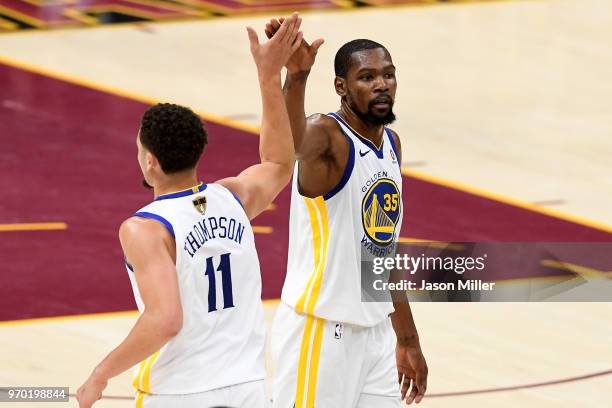 Klay Thompson and Kevin Durant of the Golden State Warriors react after a play in the second half against the Cleveland Cavaliers during Game Four of...