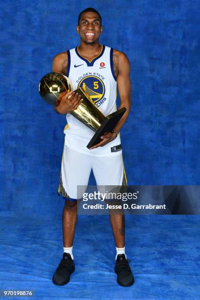 Kevon Looney of the Golden State Warriors poses for a portrait with the Larry O'Brien Championship trophy after defeating the Cleveland Cavaliers in...