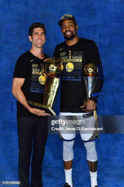 Bob Myers and Kevin Durant of the Golden State Warriors pose for a portrait with the Larry O'Brien Championship trophy and the Bill Russell Finals...