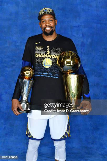 Kevin Durant of the Golden State Warriors poses for a portrait with the Larry O'Brien Championship trophy and the Bill Russell Finals MVP trophy...