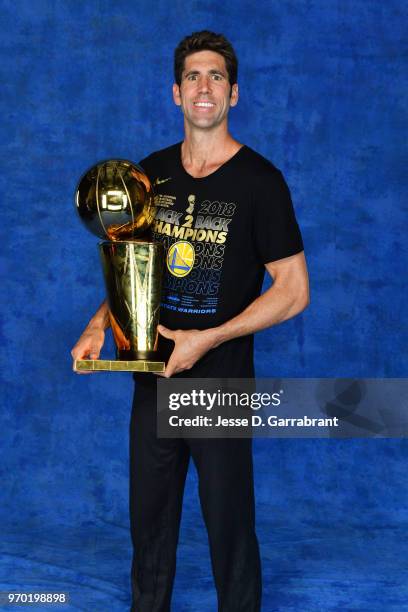 Bob Myers of the Golden State Warriors poses for a portrait with the Larry O'Brien Championship trophy after defeating the Cleveland Cavaliers in...