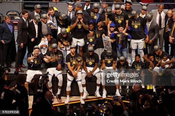 The Golden State Warriors pose for a group photo with the Larry O'Brien Championship Trophy after winning Game Four of the 2018 NBA Finals against...