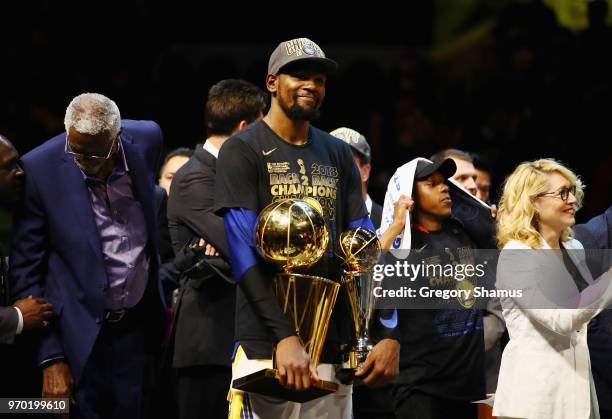 Kevin Durant of the Golden State Warriors celebrates with the Larry O'Brien Trophy and MVP Trophy after defeating the Cleveland Cavaliers during Game...