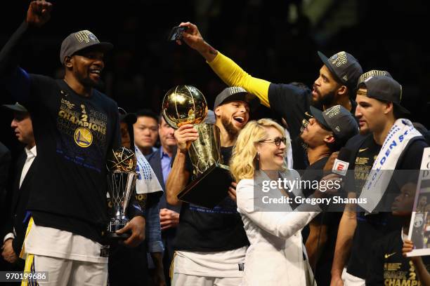 Kevin Durant of the Golden State Warriors celebrates with the MVP trophy as Stephen Curry celebrates with the Larry O'Brien Trophy after defeating...