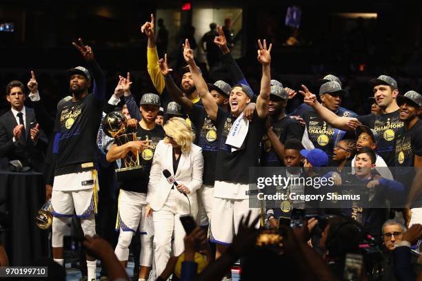 Kevin Durant of the Golden State Warriors celebrates with the MVP trophy as Stephen Curry celebrates with the Larry O'Brien Trophy after defeating...