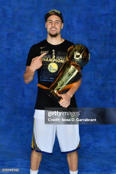 Klay Thompson of the Golden State Warriors poses for a portrait with the Larry O'Brien Championship trophy after defeating the Cleveland Cavaliers in...