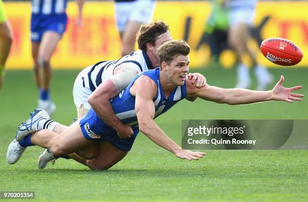 Mason Wood of the Kangaroos is tackled by Jed Bews of the Cats during the round 12 AFL match between the Geelong Cats and the North Melbourne...