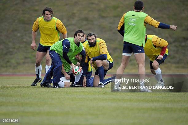 French rugby national team's scrum-half Morgan Parra passes the ball as locks Julien Pierre and Sebastien Chabal look on during a training session at...