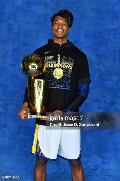 Damian Jones of the Golden State Warriors poses for a portrait with the Larry O'Brien Championship trophy after defeating the Cleveland Cavaliers in...