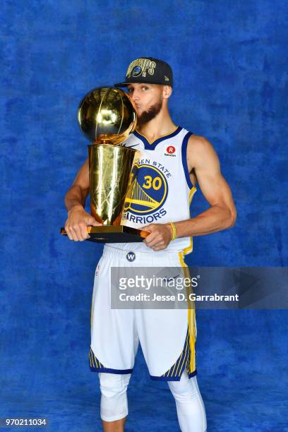 Stephen Curry of the Golden State Warriors poses for a portrait with the Larry O'Brien Championship trophy after defeating the Cleveland Cavaliers in...