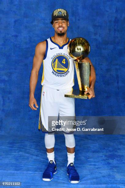Quinn Cook of the Golden State Warriors poses for a portrait with the Larry O'Brien Championship trophy after defeating the Cleveland Cavaliers in...