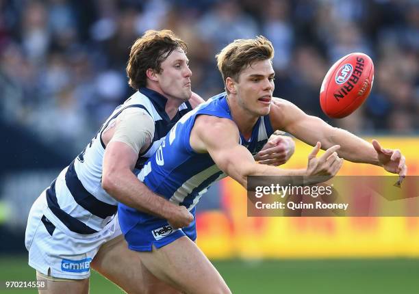 Mason Wood of the Kangaroos is tackled by Jed Bews of the Cats during the round 12 AFL match between the Geelong Cats and the North Melbourne...