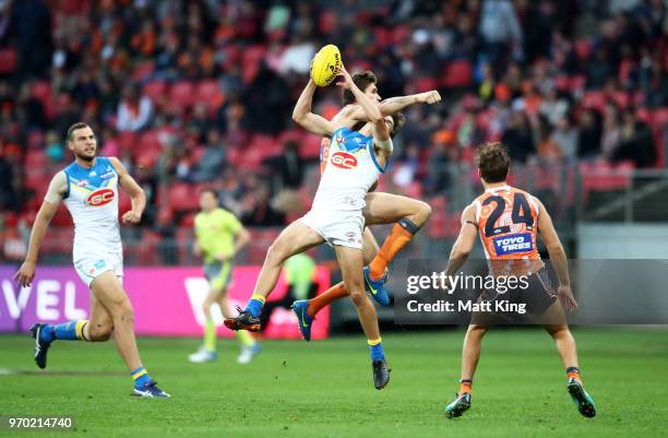 Jack Bowes of the Suns is hit by Rory Lobb of the Giants during the round 12 AFL match between the Greater Western Sydney Giants and the Gold Coast...