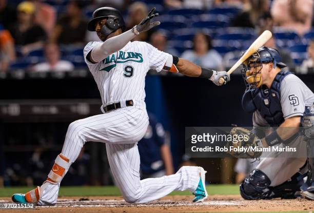 Lewis Brinson of the Miami Marlins hits catcher A.J. Ellis of the San Diego Padres on the head with his swing follow-through during the game at...