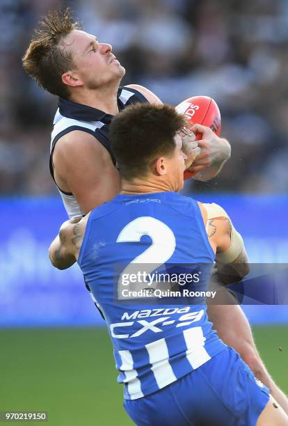 Mitch Duncan of the Cats is tackled by Marley Williams of the Kangaroos during the round 12 AFL match between the Geelong Cats and the North...