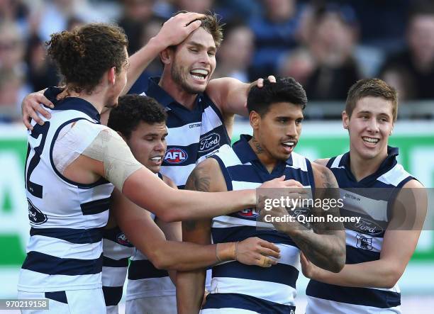 Tim Kelly of the Cats is congratulated by team mates after kicking a goal during the round 12 AFL match between the Geelong Cats and the North...