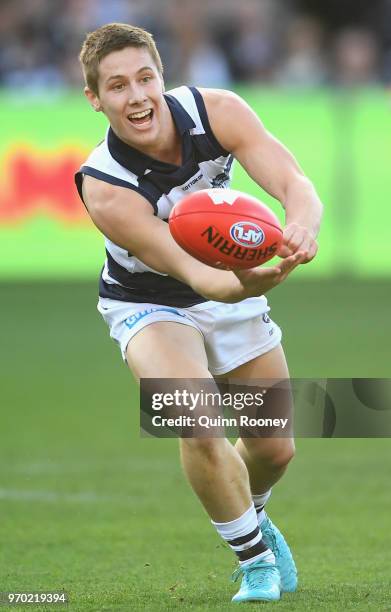 Lachine Fogarty of the Cats handballs during the round 12 AFL match between the Geelong Cats and the North Melbourne Kangaroos at GMHBA Stadium on...