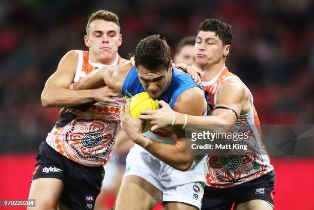Jack Leslie of the Suns is challenged by Zac Langdon and Jonathon Patton of the Giants during the round 12 AFL match between the Greater Western...