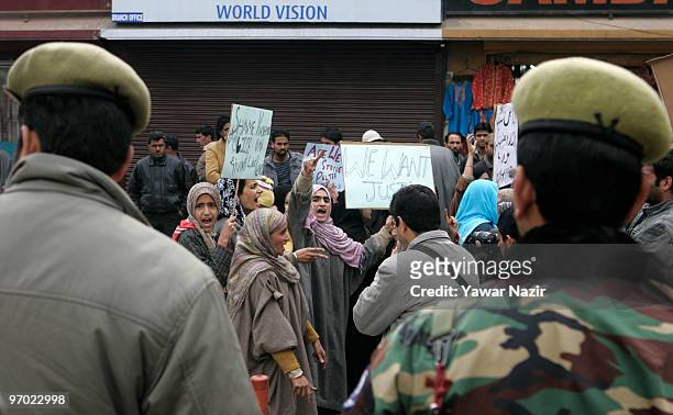 Indian police look on as neighbors and relatives of Wamiq Farooq, a 13-year-old teenager who was killed by a teargas shell fired by Indian police...