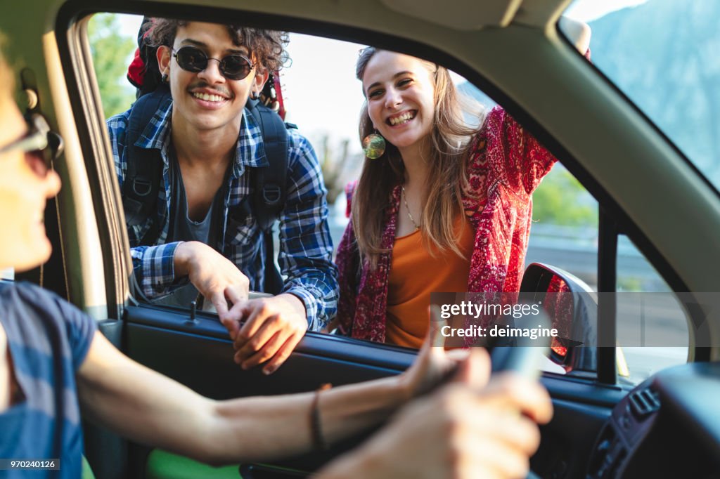 Rucksacktouristen, die per Anhalter unterwegs