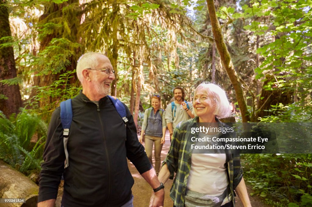 Senior couple and family hiking in forest
