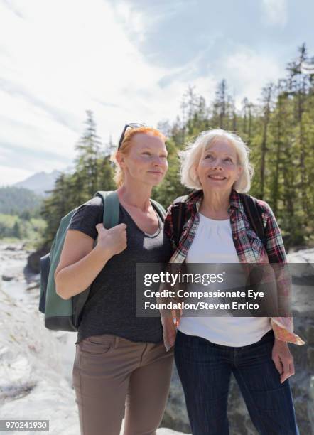 senior woman and daughter hiking in mountains - pulsante di apertura o di chiusura foto e immagini stock