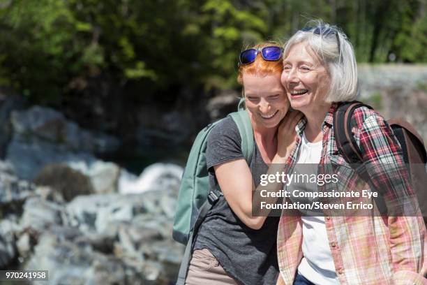 senior woman and daughter hiking in mountains - pulsante di apertura o di chiusura foto e immagini stock