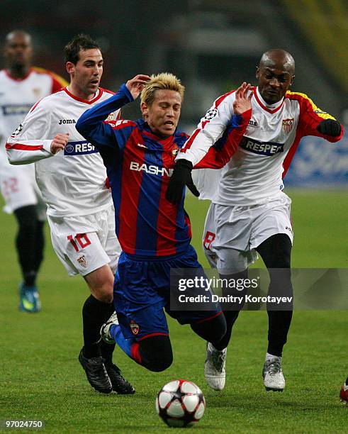 Keisuke Honda of PFC CSKA Moskva fights for the ball with Fernando Navarro and Didier Zokora of Sevilla FC during the UEFA Champions League round of...