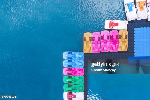 colorful pedal boats in blue water. directly above, aerial view. drone view. - paddleboat stock pictures, royalty-free photos & images