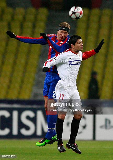 Vasili Berezutski of PFC CSKA Moskva competes for a header with Renato of Sevilla FC during the UEFA Champions League round of sixteen, first leg...