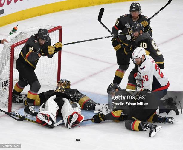 Colin Miller, Marc-Andre Fleury and Luca Sbisa of the Vegas Golden Knights defend the net from a shot by Christian Djoos of the Washington Capitals...