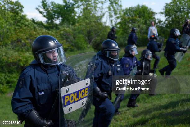 Riot police pushing the protesters back during a protest rally by the masked protesters to denounce the G7 summit in Quebec City, Canada, on 8 June...