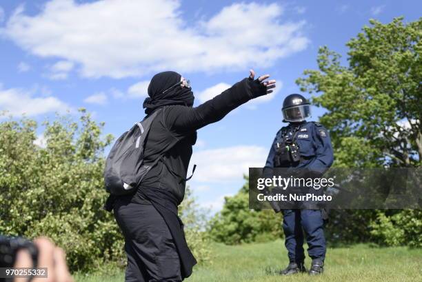 Masked protester explaining the reason for their protest to the riot police officers during a protest rally by the masked protesters to denounce the...