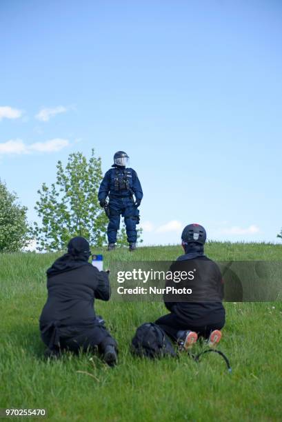 Masked protester explaining the reason for their protest to the riot police officers during a protest rally by the masked protesters to denounce the...