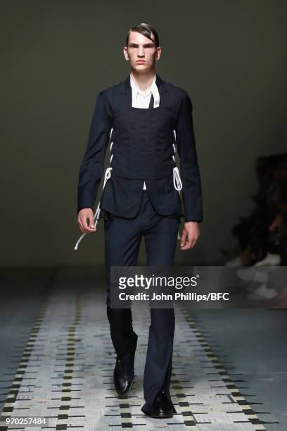 Model walks the runway at the Daniel W. Fletcher show during London Fashion Week Men's June 2018 at BFC Show Space on June 9, 2018 in London, England.
