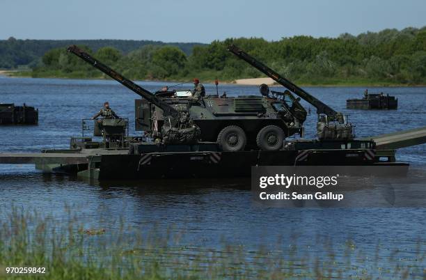 Fuchs armoured personnel carrier of the Bundeswehr, the German armed forces, rides on a military ferry comprised of M3 amphibious rigs on the Neman...