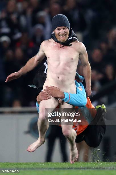 Streaker is tackled during the International Test match between the New Zealand All Blacks and France at Eden Park on June 9, 2018 in Auckland, New...