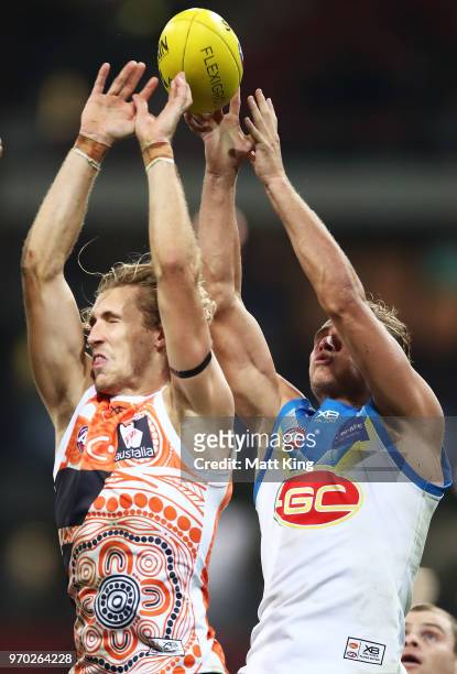 Nick Haynes of the Giants is challenged by Will Brodie of the Suns during the round 12 AFL match between the Greater Western Sydney Giants and the...