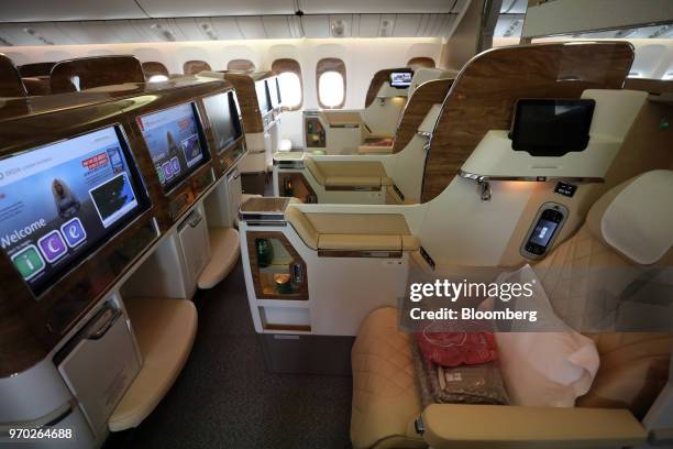 Inflight entertainment screens and seating configurations stand in a business class cabin on board a Boeing Co. 777-300ER passenger jetliner,...