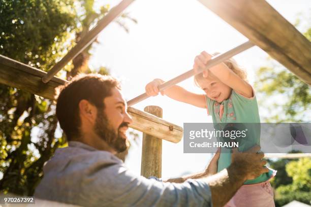 padre feliz jugando con la hija en el gimnasio de la selva - monkey bars fotografías e imágenes de stock