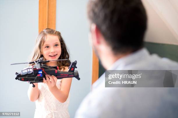 excited girl showing helicopter to father at home - toy helicopter stock pictures, royalty-free photos & images