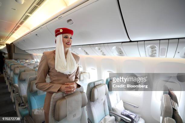 Flight attendant stands in the economy class cabin on board a Boeing Co. 777-300ER passenger jetliner, operated by Emirates Airline, at London...