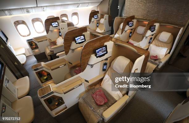 Seating configurations stand in a business class cabin on board a Boeing Co. 777-300ER passenger jetliner, operated by Emirates Airline, at London...
