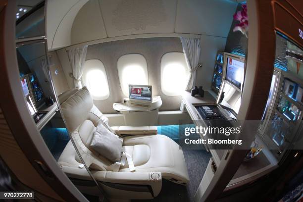 Cushion sits on a chair in a first class private suite on board a Boeing Co. 777-300ER passenger jetliner, operated by Emirates Airline, at London...