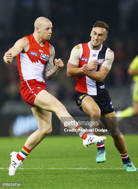 Zak Jones of the Swans kicks the ball from Luke Dunstan of the Saints during the round 12 AFL match between the St Kilda Saints and the Sydney Swans...