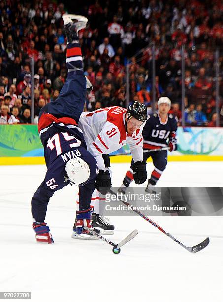 Bobby Ryan of the United States gets upended by Mathias Seger of Switzerland during the ice hockey men's quarter final game between USA and...