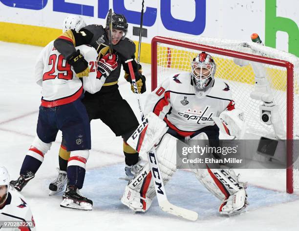 Nicklas Backstrom of the Washington Capitals and David Perron of the Vegas Golden Knights battle for position in the crease next to Braden Holtby of...