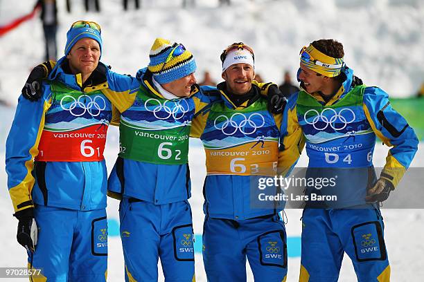 Daniel Richardsson, Johan Olsson, Anders Soedergren and Marcus Hellner of Sweden pose in the flower ceremony after winning the gold during the cross...